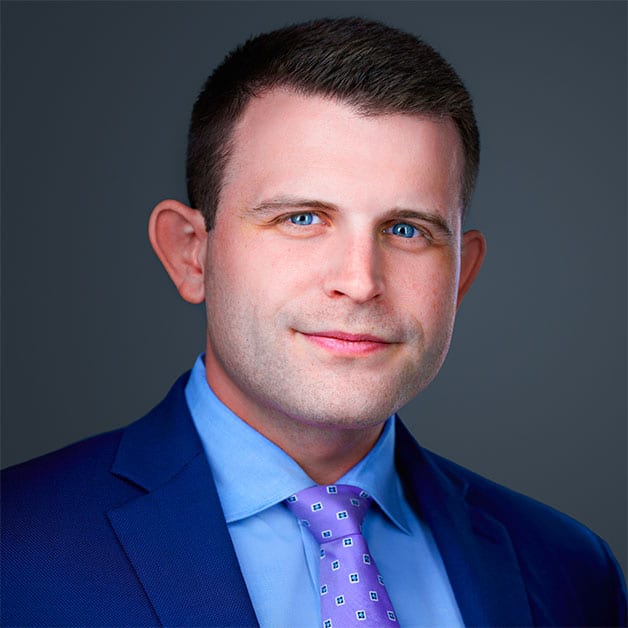 A man in a suit and tie, Andrew D. Davis, is posing for a photo.