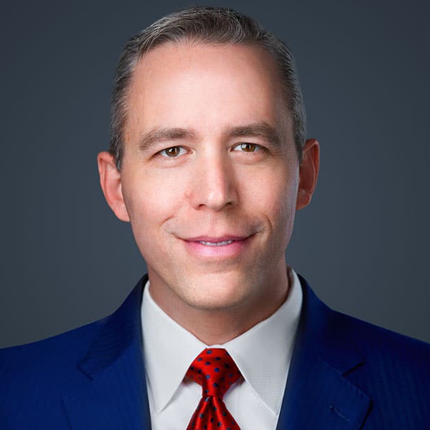 Jim Carman in a blue suit and red tie.