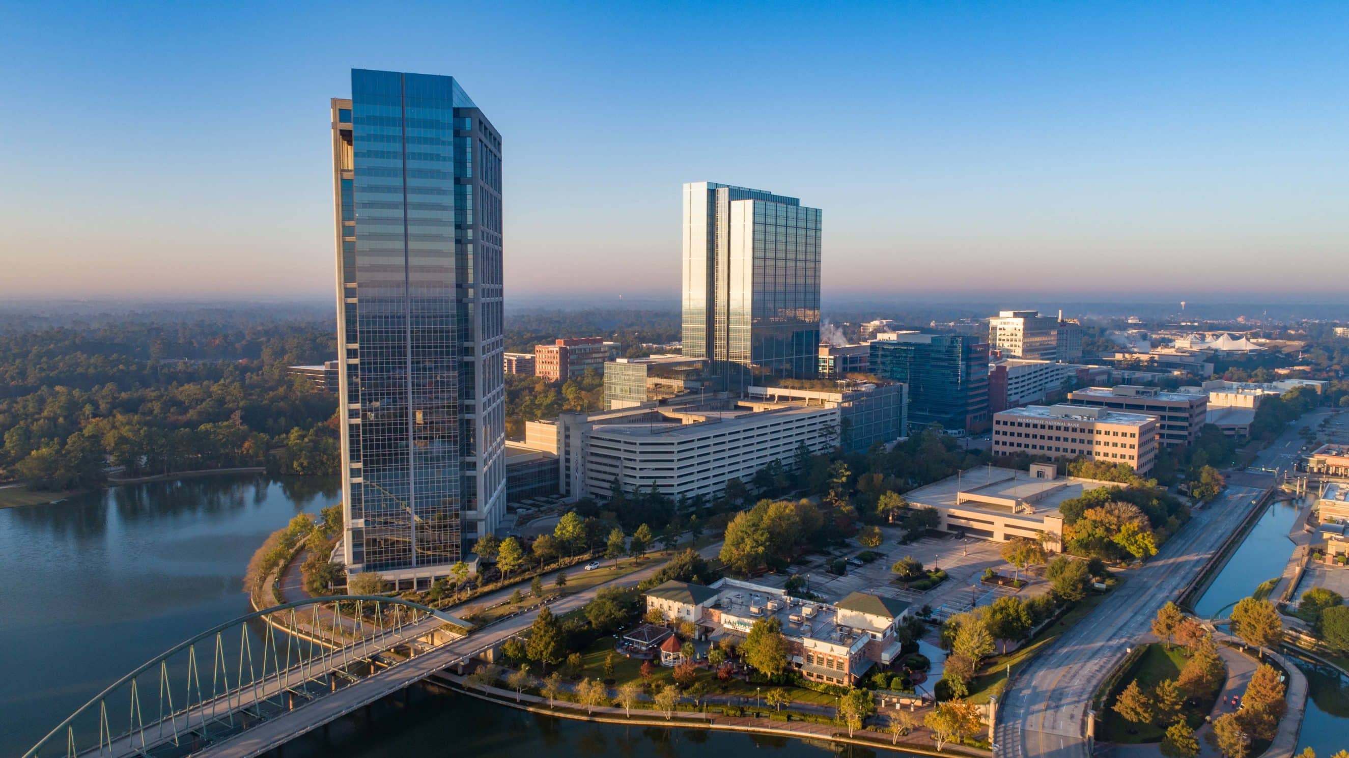 An aerial view of a city with tall buildings and a river, showcasing HHC's office leases and flexible office space solutions.