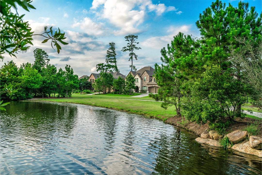 View of lake shore and single-family homes in The Woodlands
